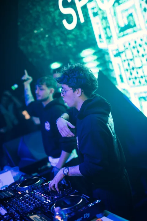 DJ Sputnik alla console durante un'esibizione illuminata di blu