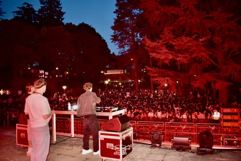 DJ Sputnik alla console davanti al pubblico di Mesiano illuminato di rosso
